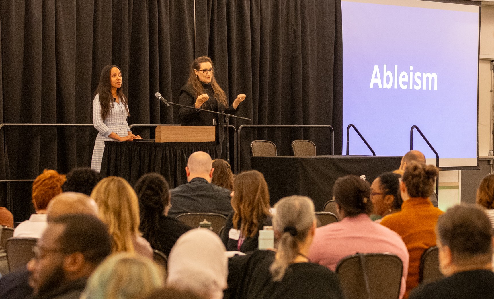 Photo of Haben Girma and ASL Interpreter speaking at Summit